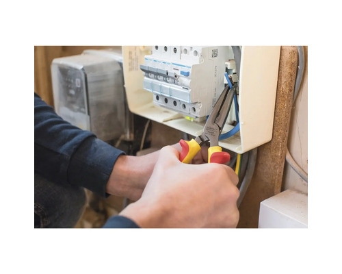 Elektricien werkt met combinatietang aan verdeelkast