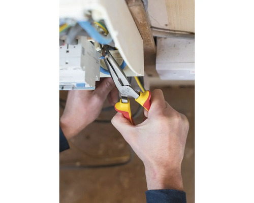 Elektricien werkt met een combinatietang aan elektrische leidingen