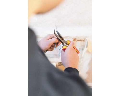 Persoon knipt kabel door met een kniptang