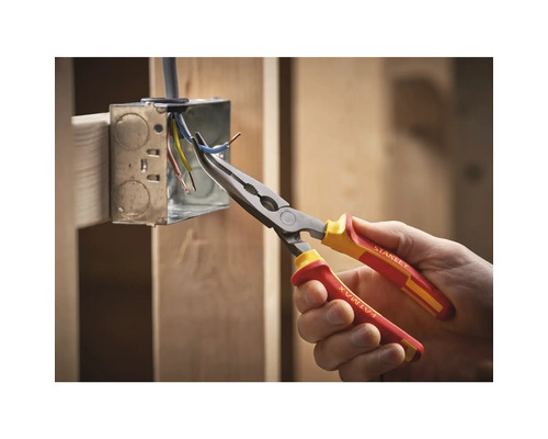 Een hand houdt een gebogen punttang van het merk Stanley vast voor het bewerken van kabels in een verdeeldoos.