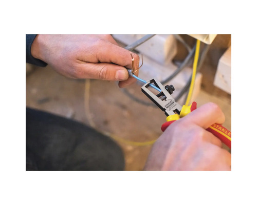Een persoon gebruikt een Stanley draadstripper om de isolatie van een kabel te verwijderen.