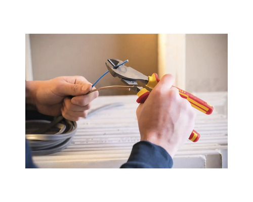 Elektricien knipt een kabel door met een kniptang