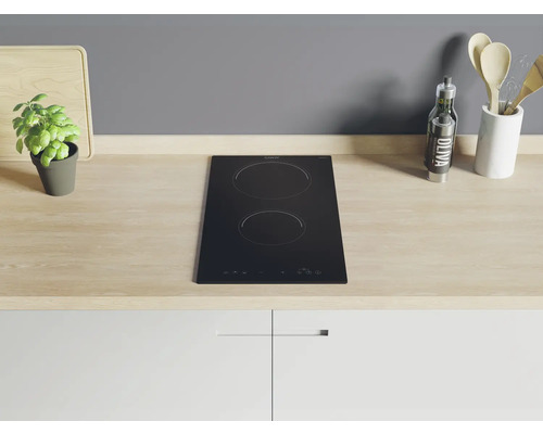 Zwarte kookplaat met twee kookzones in een keukenopstelling.