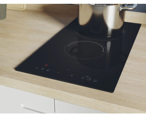 Zwarte kookplaat met twee kookzones en een pan erop