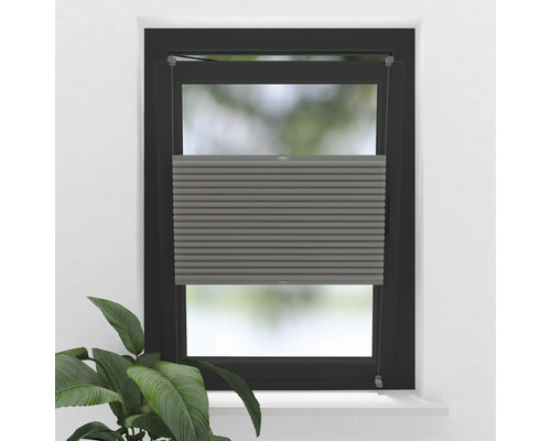 Grijze plisségordijnen op het raam voor lichtregeling