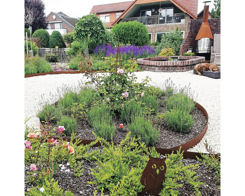 Aangelegde tuin met grindpaden, bloemperken met rozen en lavendel, tuindecoratie en stenen fontein
