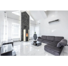 Lichte woonkamer met kachel, bank en airconditioning