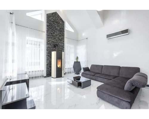 Lichte woonkamer met kachel, bank en airconditioning