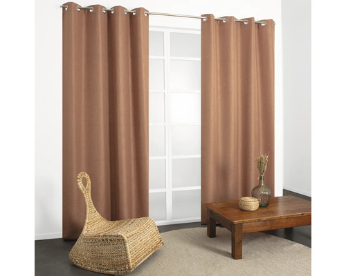 Woonkamer met gordijnen, tafel en rieten stoel