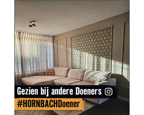 Woonkamer met hoekbank, gordijnen en wandpanelen