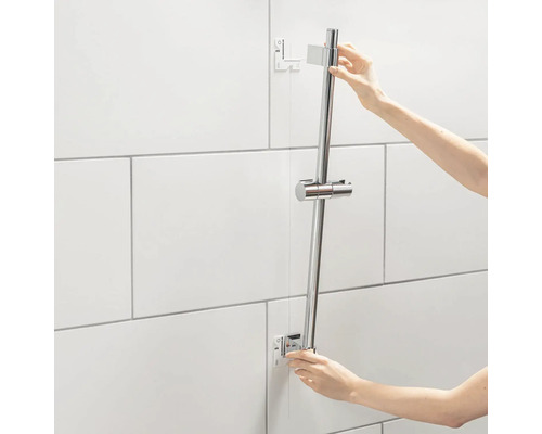 Installatie van een douchestang in een badkamer met witte tegels
