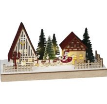 Decoratief kerstlandschap met huizen, kerstbomen, rendieren en de kerstman in een slee