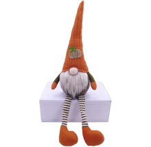 Decoratieve stoffen kabouter met gestreepte benen en een hoed met pompoenapplicatie.