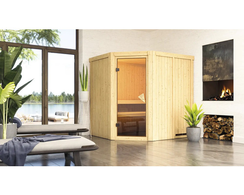 Houten sauna met glazen deur in een lichte kamer naast een open haard.