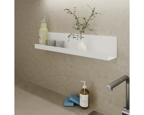 Wandplank met drankje, glazen, vaas en plant boven wastafel met zeepdispenser en spons