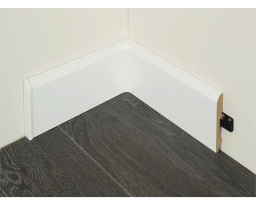 Hoek met witte plinten op een donkere laminaatvloer