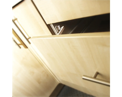 Detailopname van een gedeeltelijk geopende lade met lichte houten fronten en handgrepen