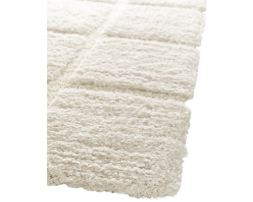 Detailopname van een lichtgekleurd, rechthoekig vloerkleed