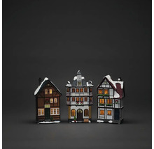 Drie decoratieve, verlichte vakwerkhuizen met sneeuw op de daken als kerstdecoratie.