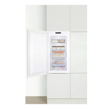 Ingebouwde vriezer met open deur in een witte keuken.