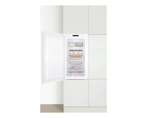 Ingebouwde vriezer met open deur in een witte keuken.