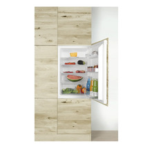 Inbouwkoelkast met open deur, gevuld met levensmiddelen in een houten keuken