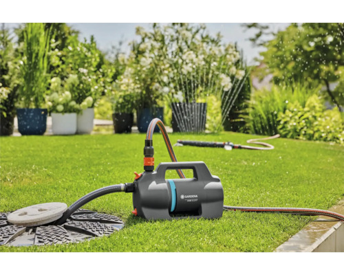 Tuin met gazon en een Gardena tuinwaterpomp voor irrigatie.