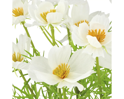 Close-up van kunstmatige witte bloemen met gele accenten en groene stelen.