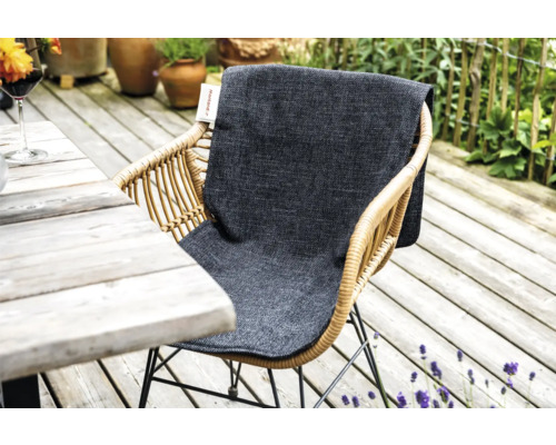 Rotan tuinstoel met grijs zitkussen op een houten terras