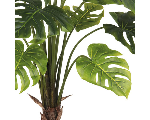 Close-up van een kunstmatige Monstera plant met groene bladeren.