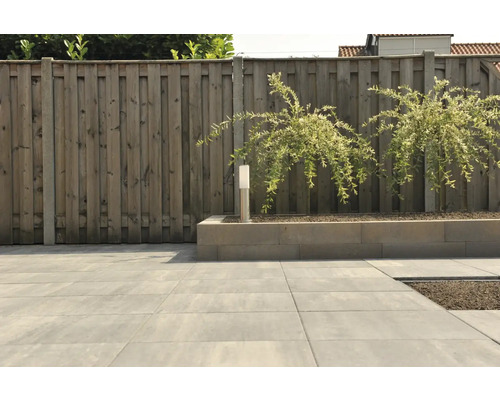 Tuinaanzicht met houten schutting, bestrating en plantenbak