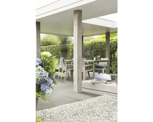 Overdekte patio met tuintafel, stoelen en decoratieve elementen.