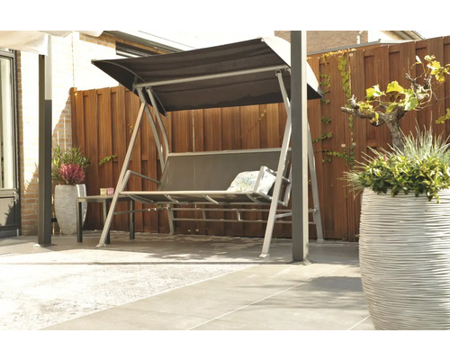 Tuinscene met een grijze schommelbank met zonnedak op een terras