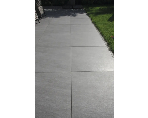 Paden van grijze terrastegels in de buitenruimte