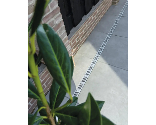 Buitenscène met afwateringsgoot langs een wandelpad