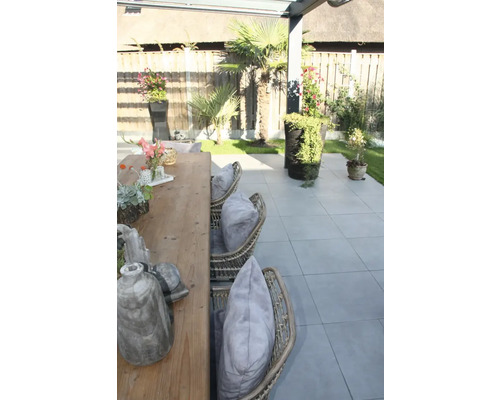 Terras met tuintafel, rotan stoelen en planten in potten