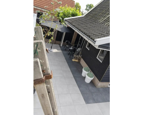 Tuin met terras, bestrating en houten schommel