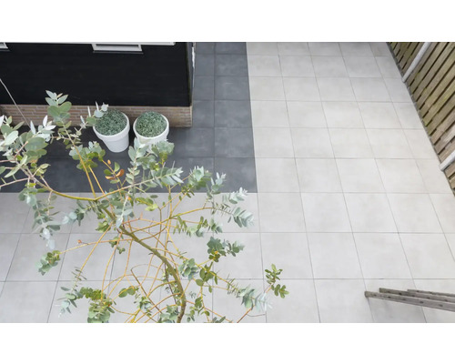 Terras met lichte en donkere tegels, planten en houten schutting