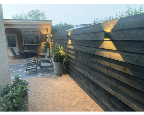 Buitenkamer met houten schutting, tuinmeubelen en verlichting