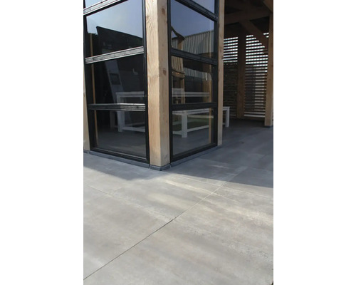 Buitenaanzicht van een terrasoverkapping met houten palen en glazen elementen