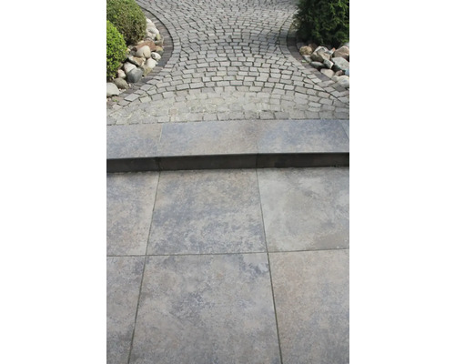 Buitenscène met straatstenen en tegels voor paden en trappen.