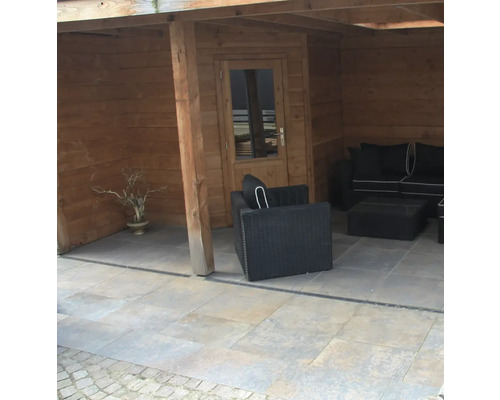 Houten tuinhuis met zithoek en stenen tegels