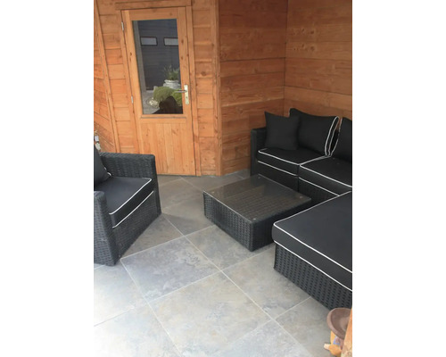 Overdekt terras met rotan zitgroep en glazen tafel