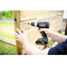 Accuboormachine die een schroef in een houten plank schroeft.