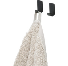 Handdoek hangt aan een zwarte haak voor wandmontage