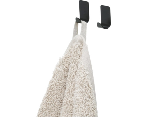 Handdoek hangt aan een zwarte haak voor wandmontage