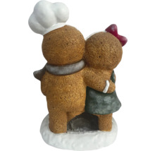 Decoratieve peperkoekfiguren die elkaar omarmen, een bakker met een koksmuts en een meisje met een strik