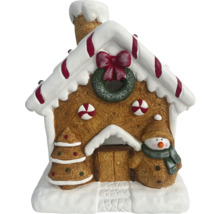 Decoratie van een peperkoekhuis met kerstboom en sneeuwpop