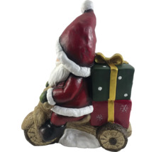 Kerstmanfiguur op houten motor met cadeaus