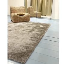 Hoogpolig tapijt met fauteuil van waterhyacint en spiegel op de achtergrond